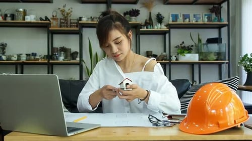 Female Architect Or Engineer use Vernier Caliper to measure the model house. Architectural Concept.