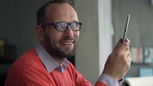 Man Uses Tablet Smiling Indoors