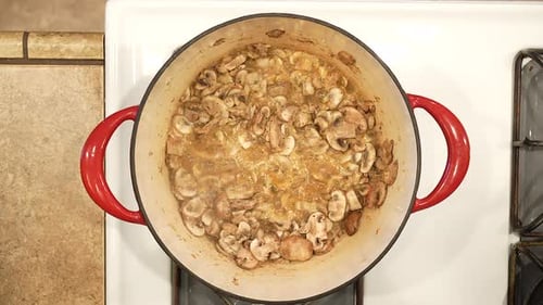 Sauteing organic cremini mushrooms in a pot on the stove for a delicious soup - overhead view WILD R