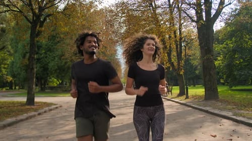 Couple Running Together in an Autumn Park