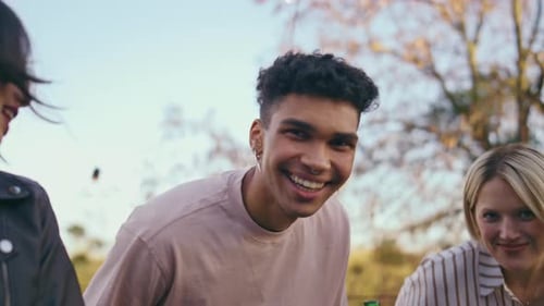 Friends Smiling and Socializing at Outdoor Gathering