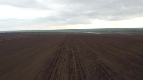 Blue tractor OA working on the field in Ukraine