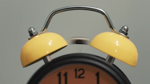 Vintage alarm clock sounding the alarm in the morning. Bell of an alarm clock ringing.