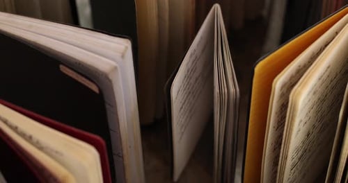 Shot tilted down tracks past close-up of old notebooks