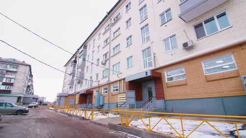 Motion Past Renewed Apartment Building on Winter Day