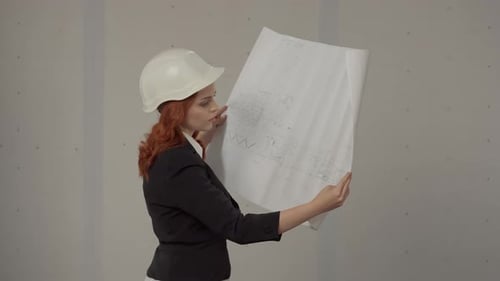 Side View of an Architect Woman Holding a Plan in Her Hands A Woman is Studying the Project Plan