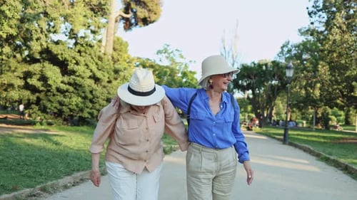 Happy senior women walking and having fun in park