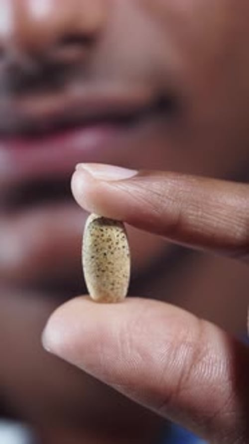 Close Up of Vitamin Capsule in Hand