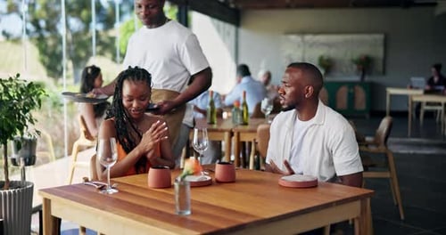 Happy couple, waiter and serving food with plate for fine dining or romantic dinner in restaurant