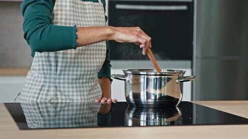 Unknown Housewife Mistress Maid Wife Mom Wears Apron Prepare Food on Kitchen Surface Electric Oven