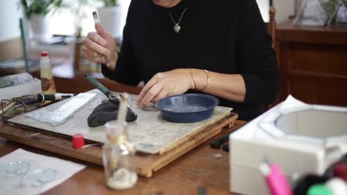 A woman making a stained glass work