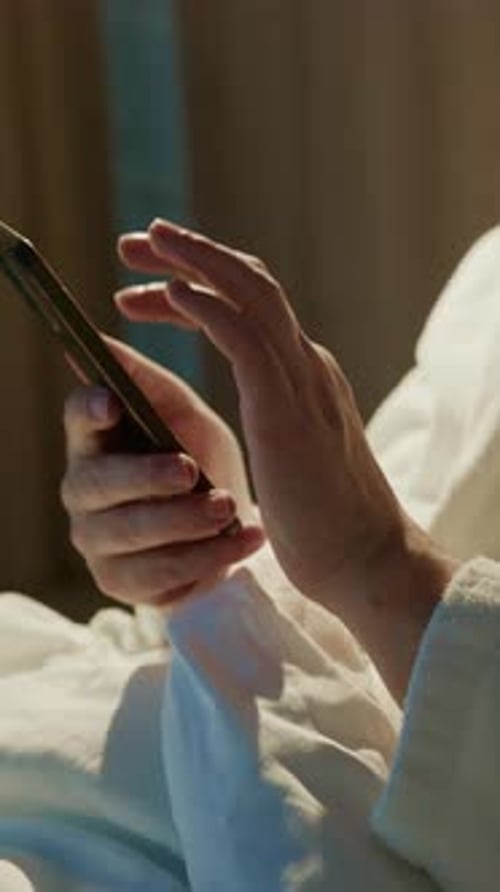 Hands Using Mobile Phone in Bed, Close Up