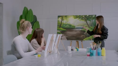 Three Women are Painting a Picture of a River
