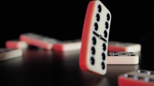 White domino dice fall on a black background. Slow motion
