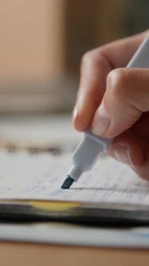 Utilisation manuelle d'un surligneur sur des notes manuscrites dans un bloc-notes