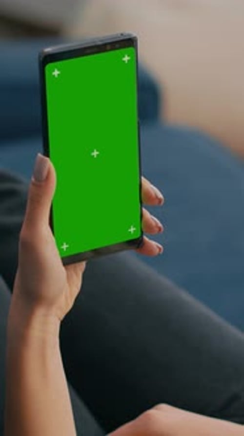 Vertical Video Freelancer Holding in Vertical Mode Smartphone with Mock Up Green Screen Chroma Key