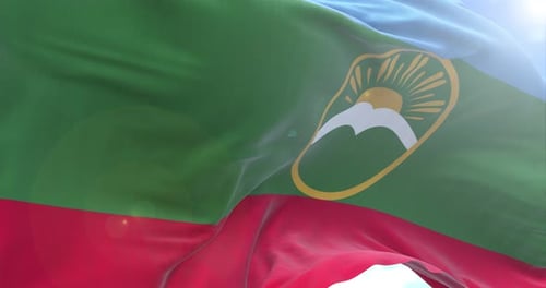 Dynamic Waving Flag with Sun, Mountain, Bird Emblem against Blue Sky