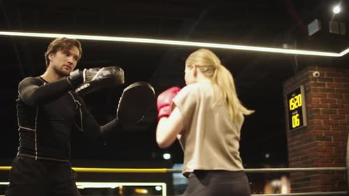 Woman Boxing with Trainer in Boxing Ring