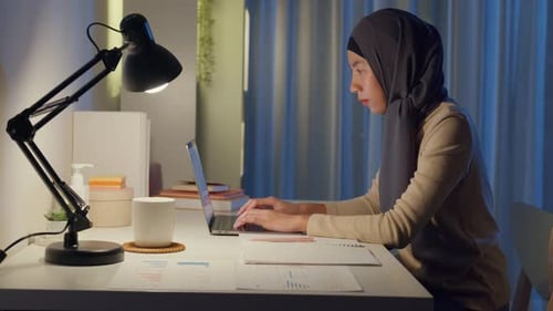 Young Woman Works at Desk at Night