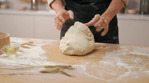Hands Kneading Dough on a Floured Kitchen Counter