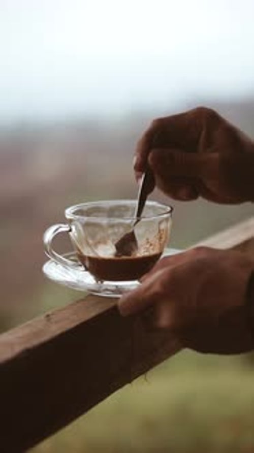 Stirring a Cup of Coffee Outdoors