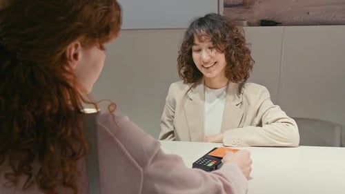 Woman Pays with Card at Retail Counter