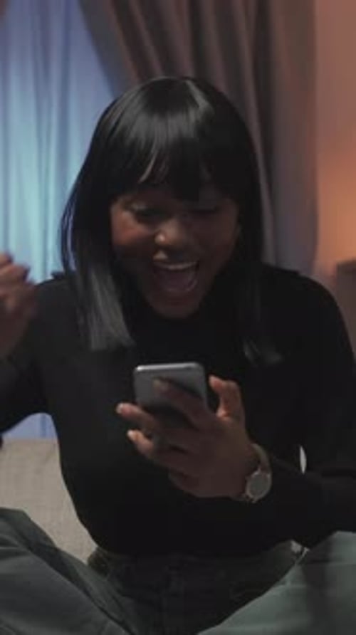 Woman Celebrates Success Using Her Mobile Phone