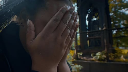 Mourning Woman Weeping at Grave in Cemetery