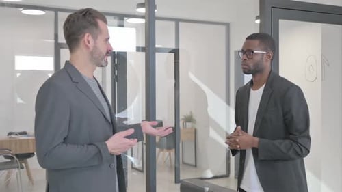 Multi Ethnic Teammates Talking while Standing in Office