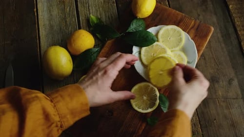 Frische Zitronen in Scheiben für die Sommerlimonade zubereiten