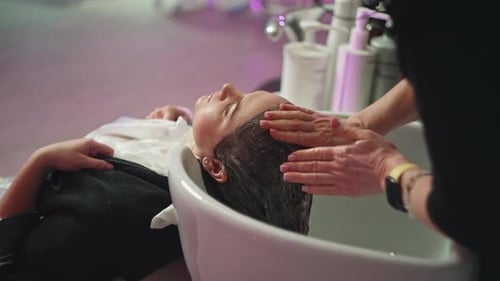 Hair Stylist Massaging Scalp at Salon Shampoo Bowl