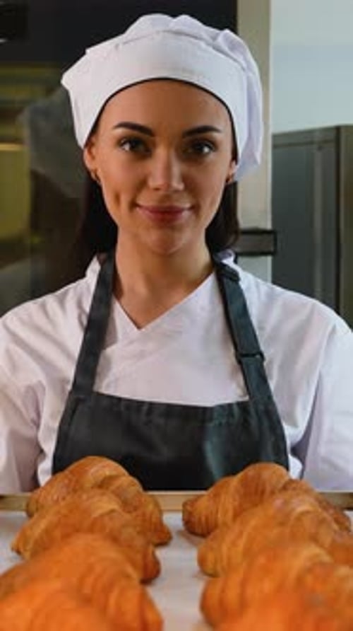 Female Baker Proudly Presents Freshly Baked Croissants