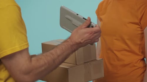 Closeup Shot Delivery Man in Yellow Uniform Gives a Female Customer Her Packages She Signs the Order