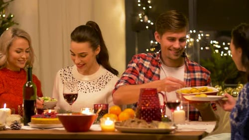 Friends Eating Christmas Dinner at Home at Night