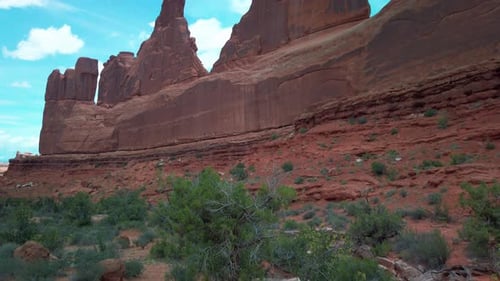 Wide tilting up shot of the rock formations along the Park Avenue Trail in Arches National Park, Uta