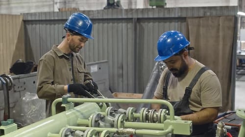 Mechanics Working with Wrenches while Fixing Machinery Equipment at Factory