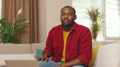Man Relaxing on Couch with Laptop in Home