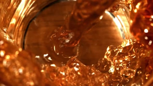 Amber Liquid Pouring into Glass Close-Up