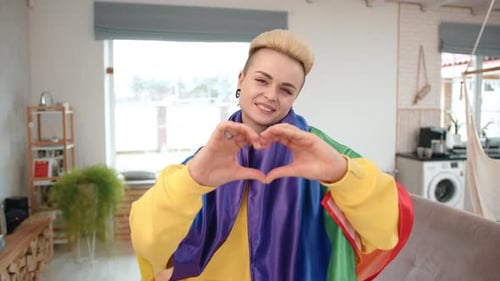 Happy Woman Makes Heart With Hands Wearing Pride Flag