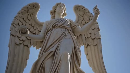 The Majestic Angel Statue Stands Proudly Against a Clear Blue Sky Radiating Grace and Beauty