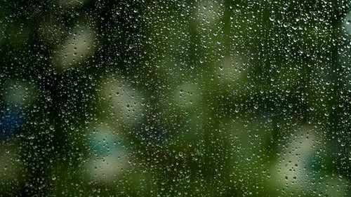 Large Drops On Glass From Rain Against A Green Background