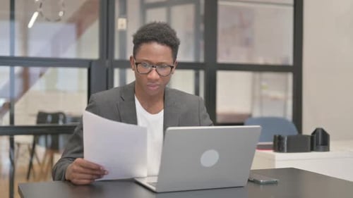 Young Adult Man Reading Documents at Desk