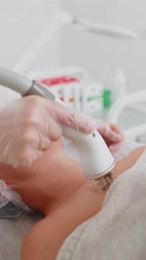 Beautician Makes Woman RF Lifting Cosmetology Procedure of Face and Eyes Area Collagen Mask at Spa