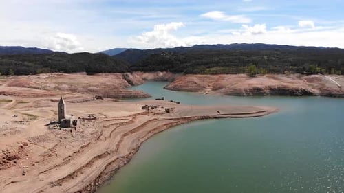 Empty reservoir with a ruined church. Aerial shot