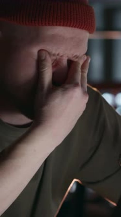 Man Removing Glasses and Leaning Closer to Laptop in Disbelief