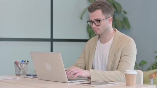 Young Adult Typing on Laptop and Coughing