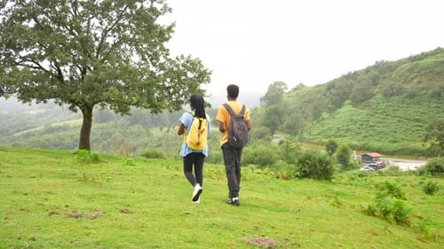 Young Couple Hiking in Lush Green Hills