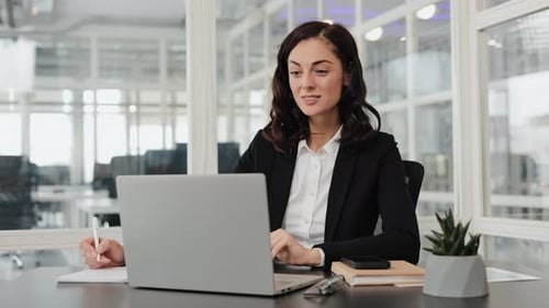 Geschäftsfrau arbeitet im Büro am Laptop