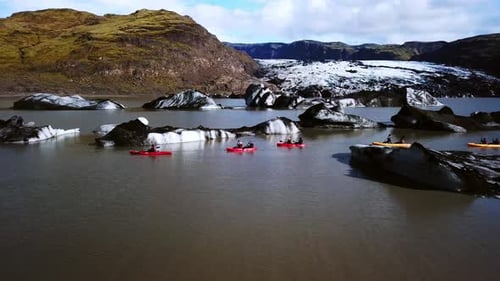 Vista aérea da paisagem de pessoas andando de caiaque perto da geleira Sólheimajökull, Islândia, em um dia ensolarado