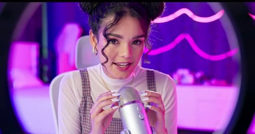 Smiling Woman Talks into Microphone with Ring Light
